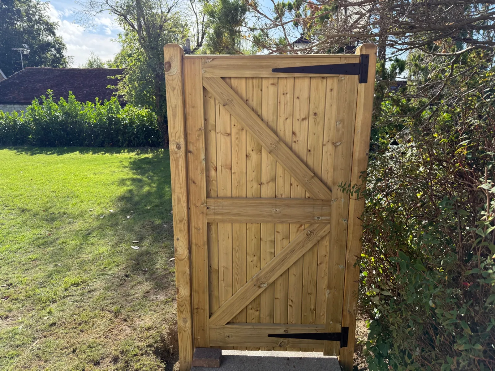 Braced timber garden gate hung on posts in a back garden